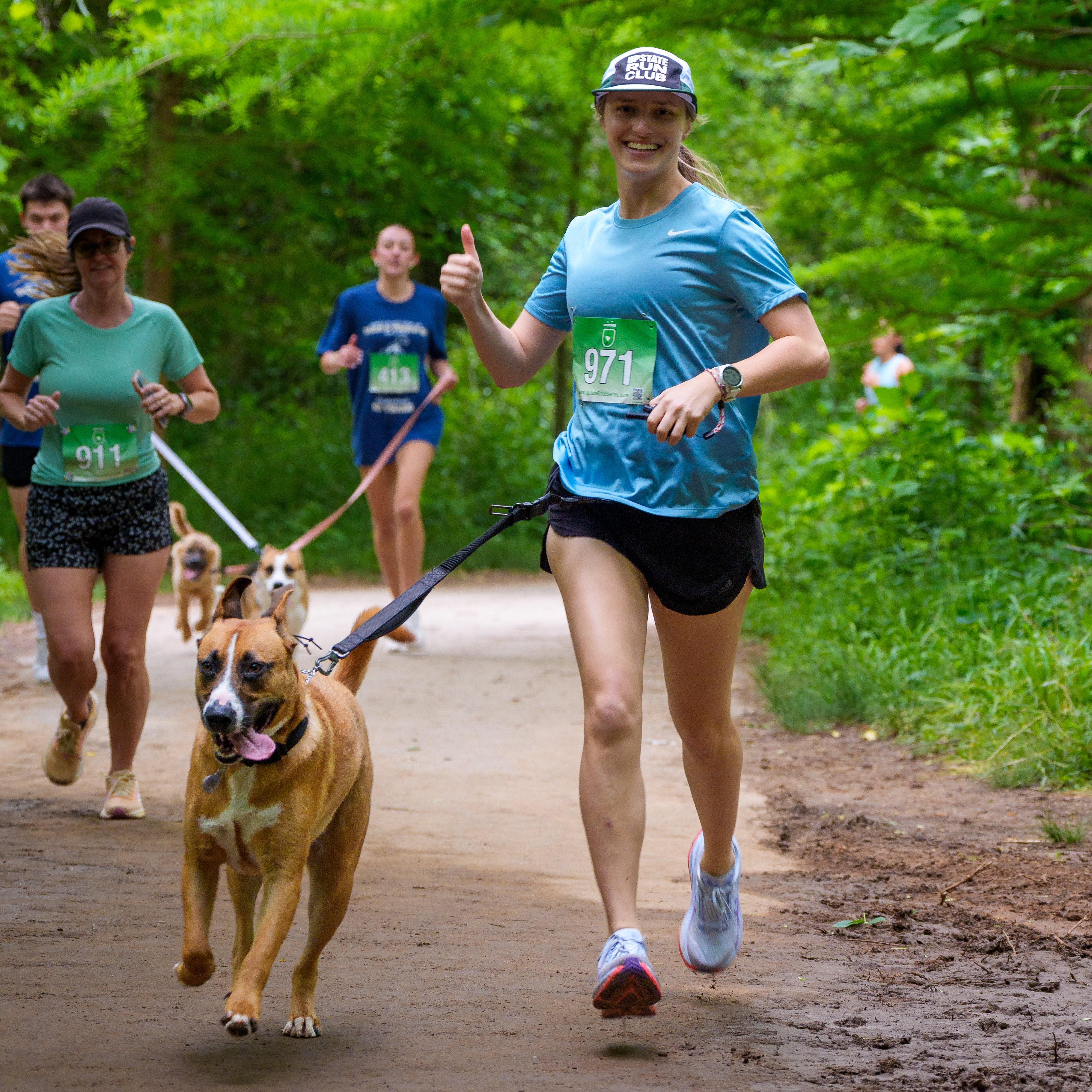 Woman running with a dog on a leash in a park setting